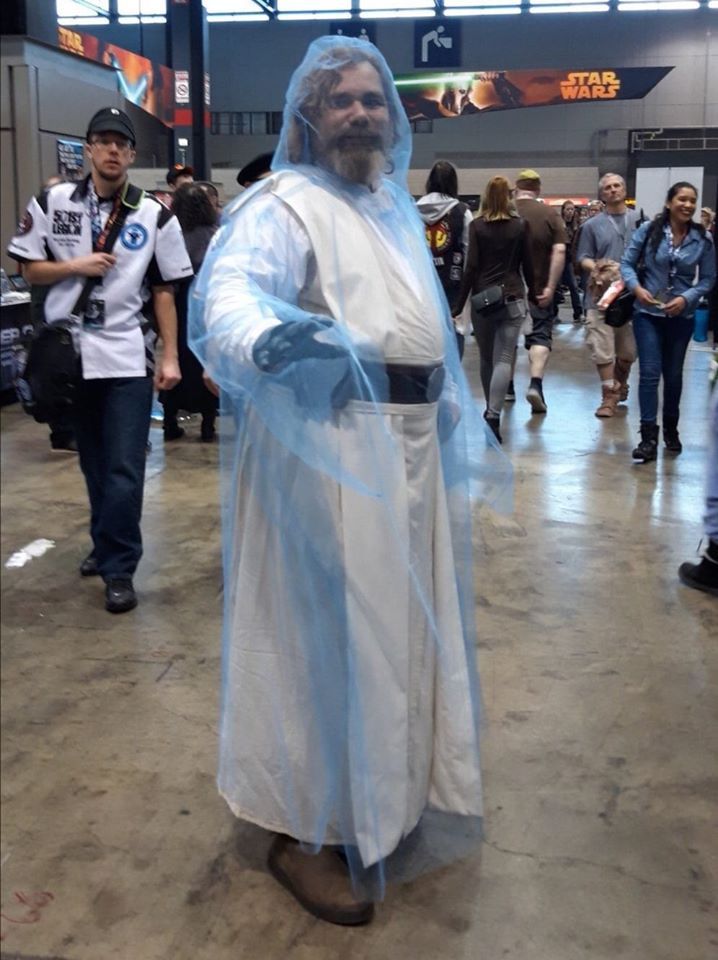 a man dressed as jesus is standing in the middle of an indoor area with people walking around