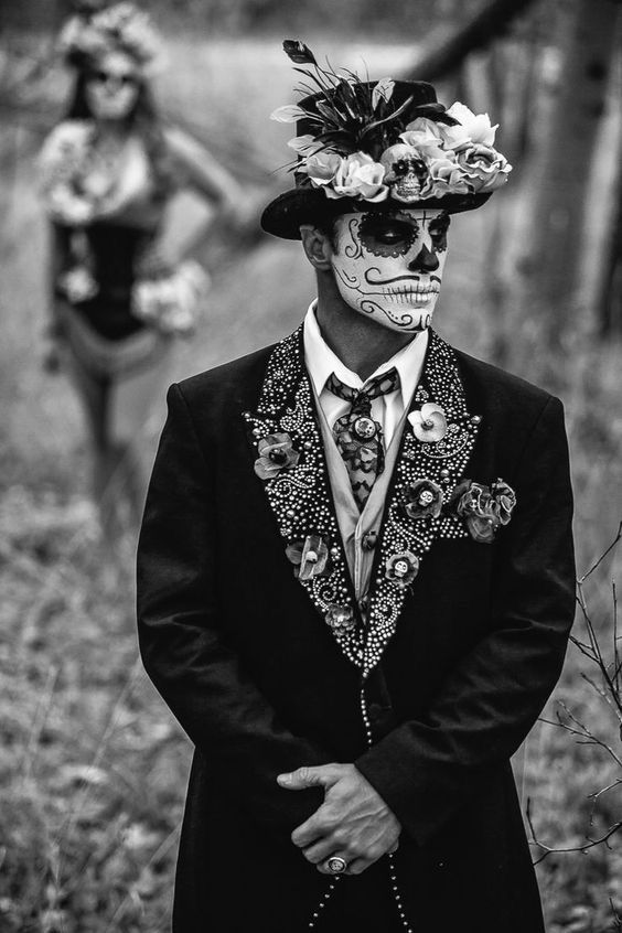 a man in a suit and hat with flowers on his head