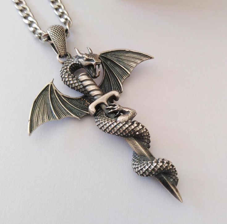 ★ Dragon Pendant ★ Handcrafted Dragon with Sword pendant/necklace for Men and Women. * Materials/Finishes ➤ Artificially Aged (Black/Grey Oxidized) Silver 925 * Dimensions ➤ ~ 5.5 x 4.2 x 1.0 cm (~ 2.2 x 1.7 x 0.4 inches)/Bail: Suitable for up to ~ 4.5 mm (~ 0.18 inches) Chain * Weight: ~ 15 grams (in Silver 925) ----------------------------------------------------------------------------- IMPORTANT NOTES: ----------------------------------------------------------------------------- ➤ When buyin Silver Dragon, Dragon Pendant, Precious Jewels, Oxidized Silver, Stainless Steel Chain, Men Necklace, Silver Color, Black And Grey, Jewelry Necklace Pendant