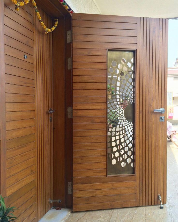 an open wooden door with decorative glass in the center and side panels on both sides