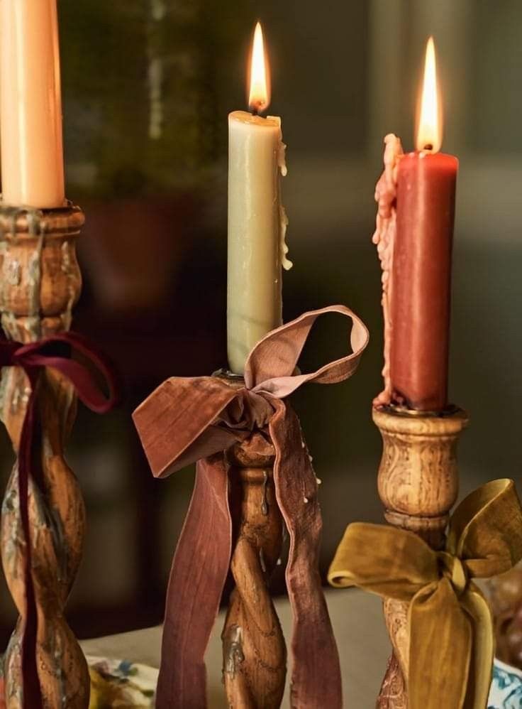 three candles with ribbons on them are sitting next to each other