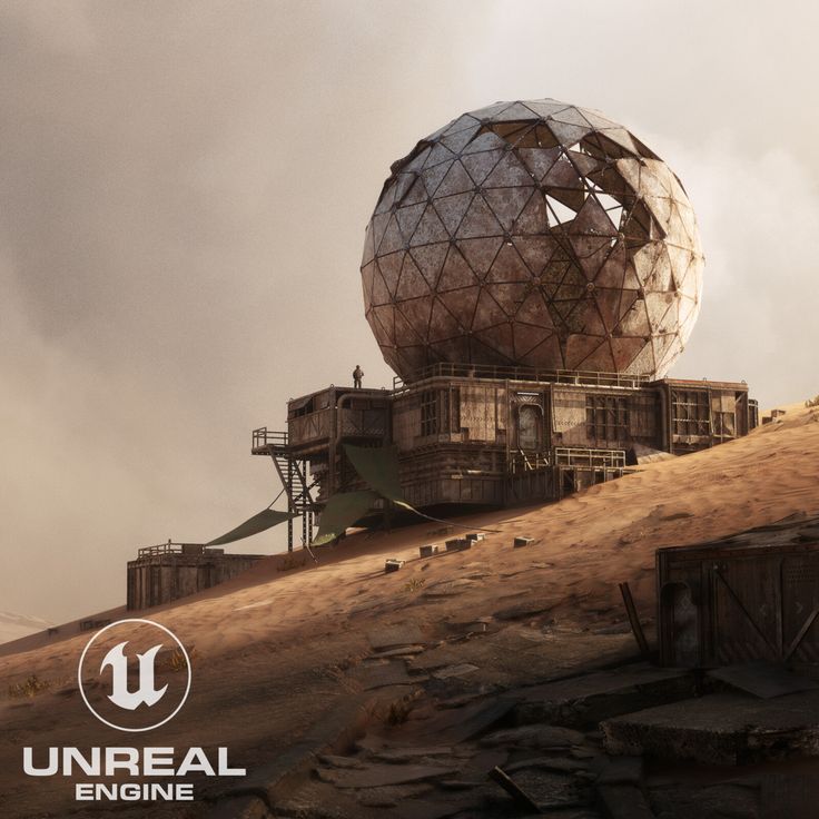 a large metal object sitting on top of a dirt hill next to a building with a giant round structure in the middle