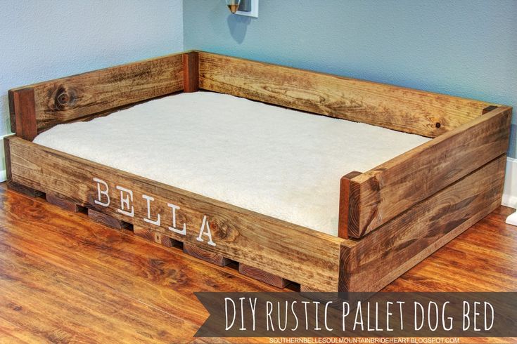 a dog bed made out of pallet wood with the word bella written on it