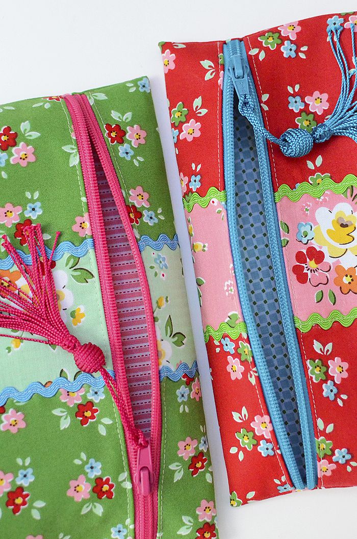 two bags with different designs on them sitting next to each other, one is pink and the other has green