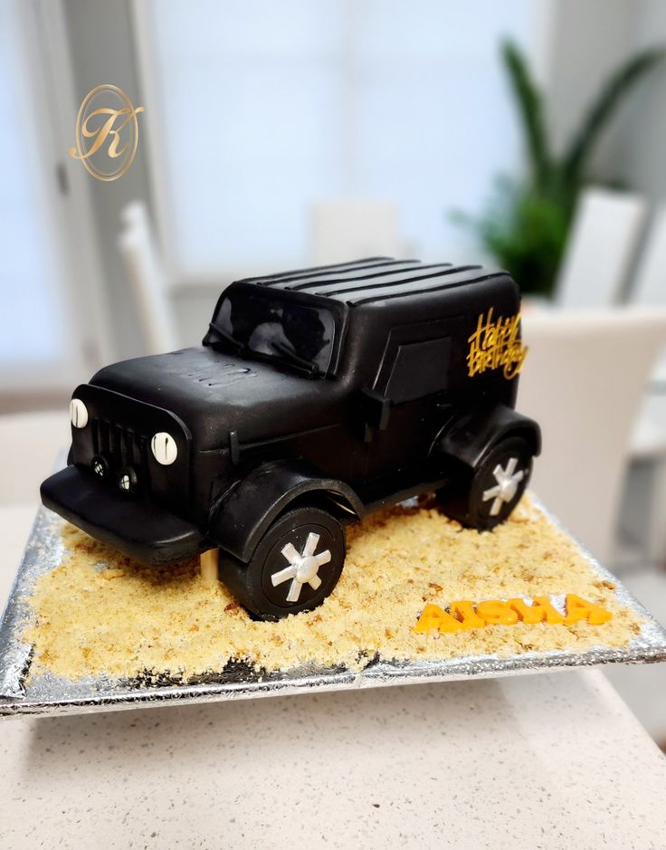 a birthday cake made to look like an old fashioned truck on top of some sand