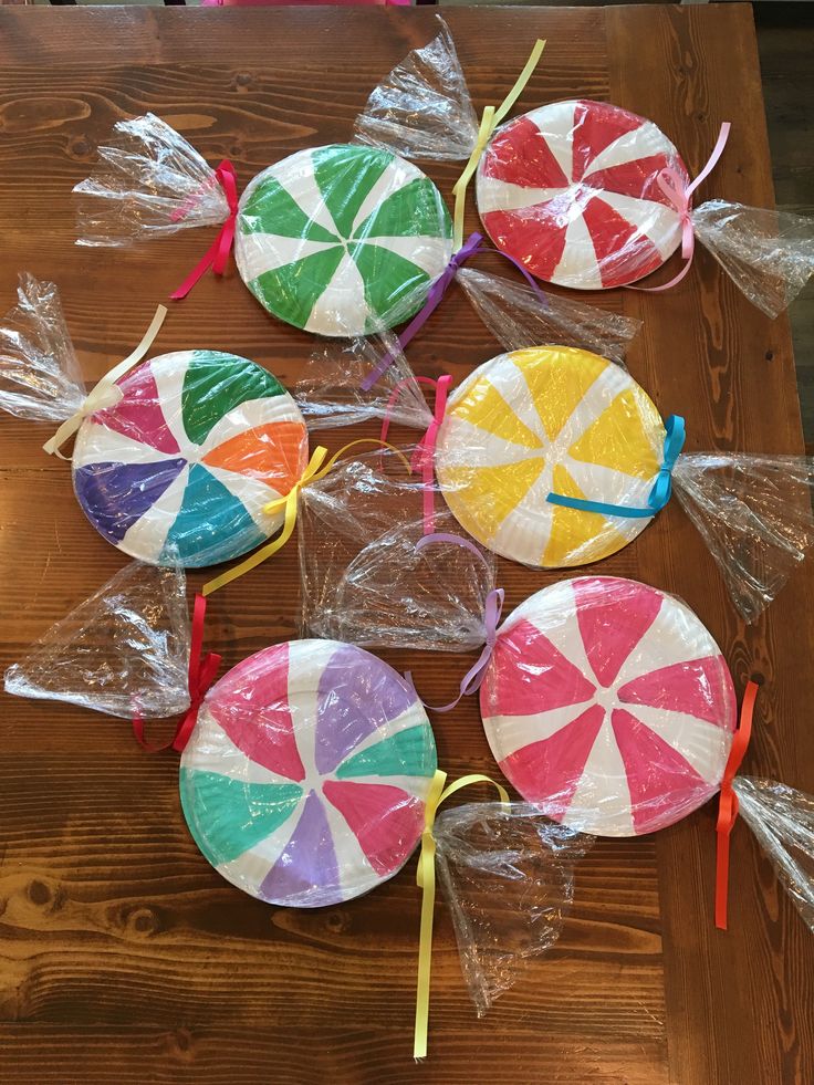 candy lollipops wrapped in cellophane and sitting on a wooden table