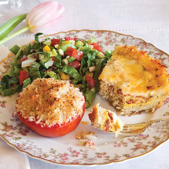 a plate with some food on it next to a fork and flowered napkins