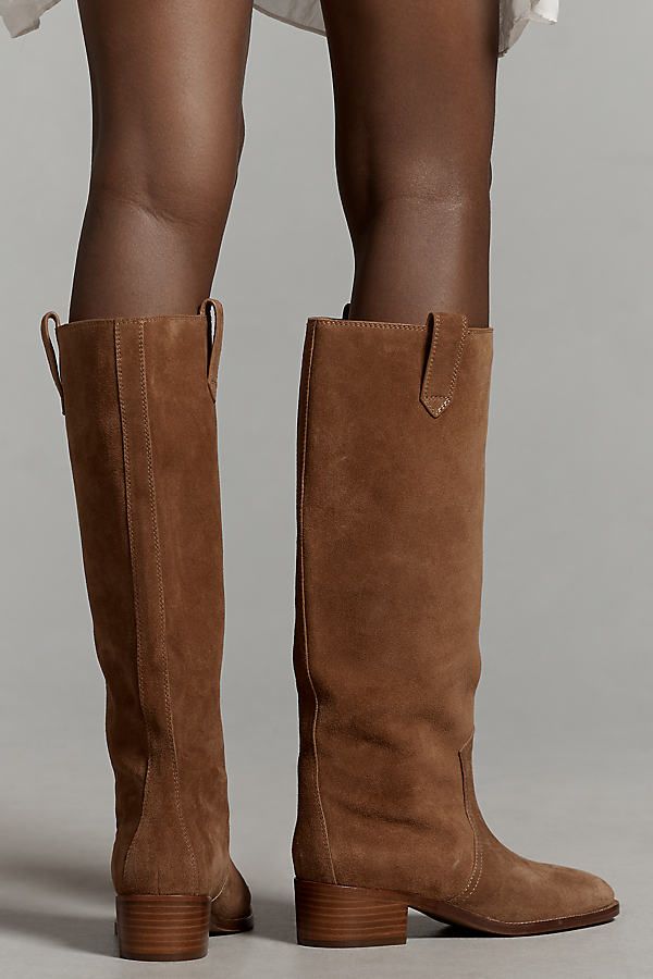 We're kicking up lust over the new Western boot trend. The Lola Cruz Cala Boots feature a knee-high silhouette with side-pull tabs and a classic Western design. | Cala Knee-High Western Boots by Lola Cruz in Brown, Women's, Size: 37, Rubber/Suede at Anthropologie Brown Boots Suede, Lola Cruz Boots, 2024 Boots Trend, Brown Boots Tall, Closet Rebuild, Best Shoes For Women, Sherling Boots, Wide Calf Boots For Women, Wide Calf Cowgirl Boots