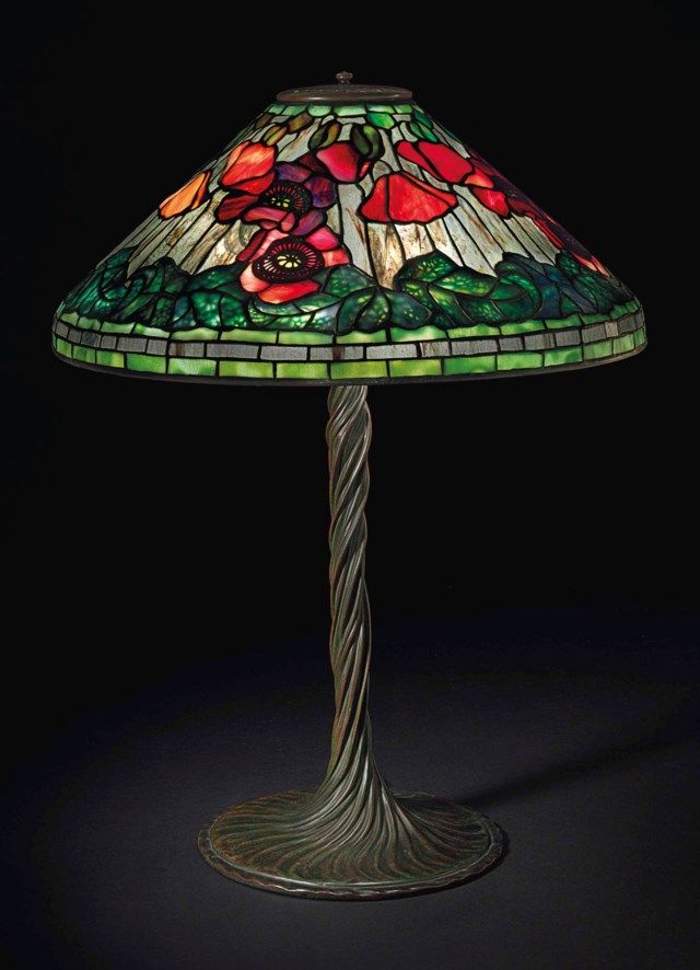 a lamp that is sitting on top of a table with a flower design on it