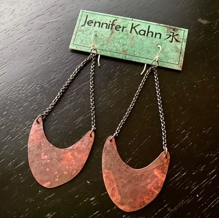 Over the years, these "Pendulum" style earrings have become one of my most popular and recognizable JK styles. Dramatic and modern yet still has an ethnic and ancient feel. Hammered, flame-patinated Copper with oxidized sterling silver chain. Delicate but noticeable and you can barely feel them in your ears! So versatile, great with a dress or jeans. Patina color may vary from light to dark, and orange to red shades. Available in 2 sizes: Tiny - 7/8" wide and is 2" long including sterling silver Pendulum Earrings, Red Shades, Patina Color, Red Orange Color, Find Objects, Heishi Beads, Oxidized Sterling Silver, Style Earrings, Sterling Silver Chain