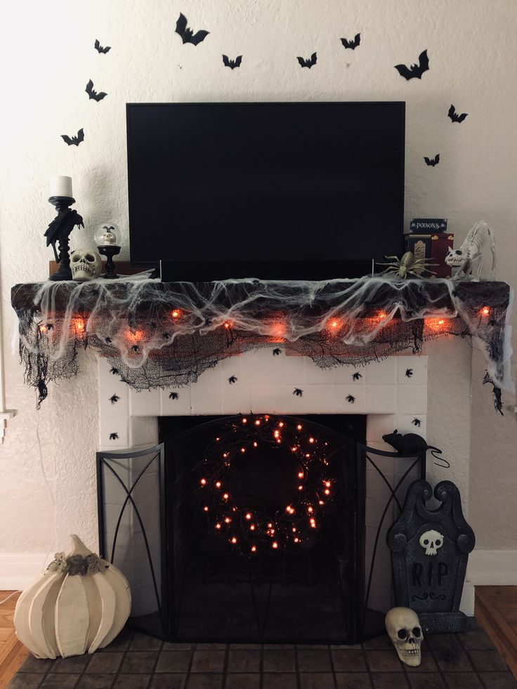 a fireplace decorated with halloween decorations and lights