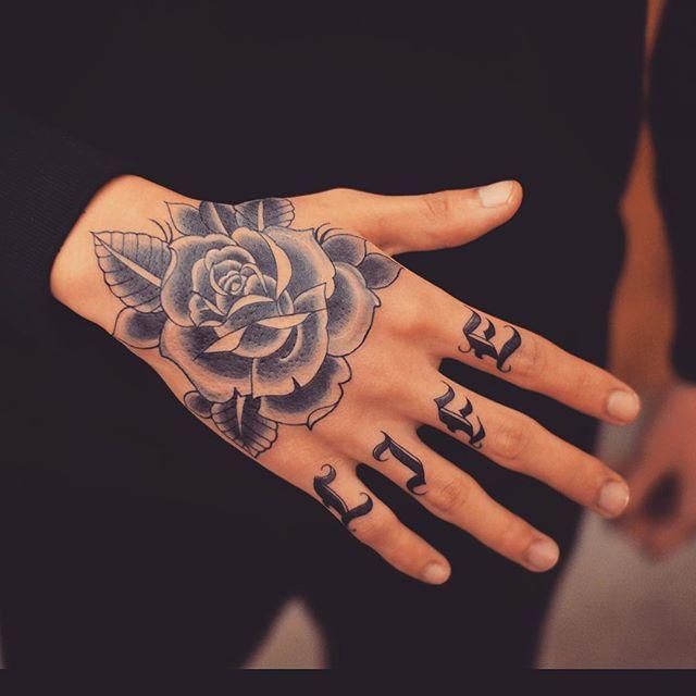 a woman's hand with arabic writing and a rose tattooed on it