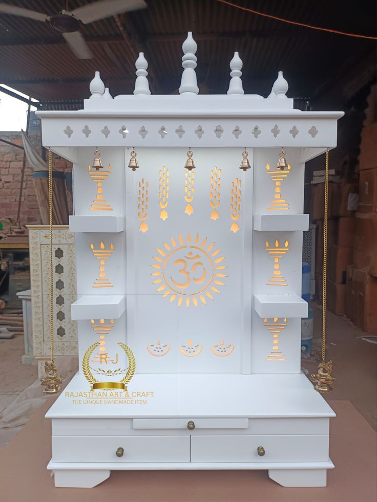 a white shrine with gold decorations on the front and back sides, surrounded by other items