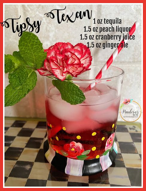 a glass filled with liquid sitting on top of a checkerboard table next to a red and white striped straw