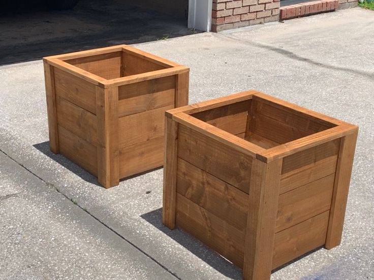 two wooden planters sitting on the sidewalk