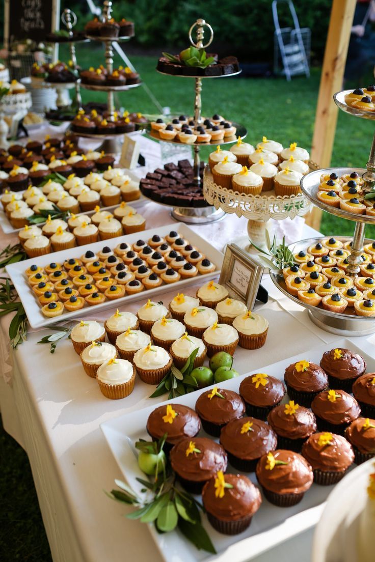 a table topped with lots of cupcakes and cakes