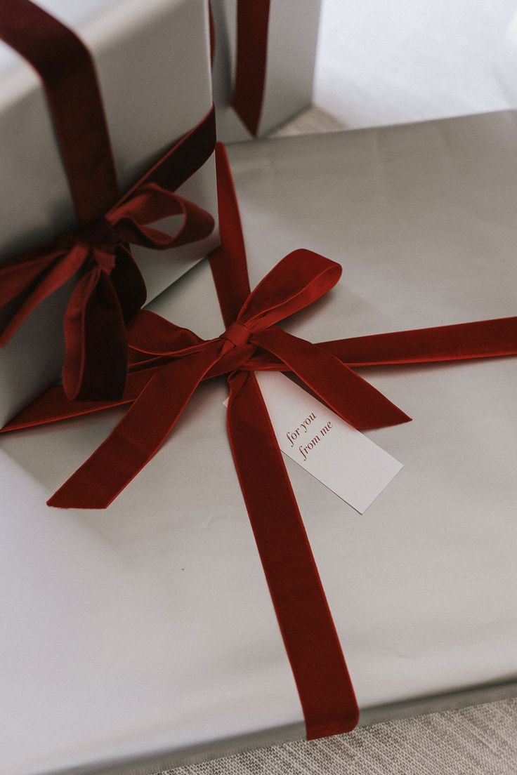 two wrapped presents tied together with red ribbon