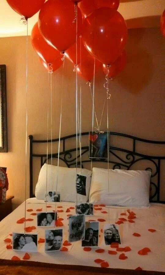 red balloons floating over a bed with pictures on the sheets and pillow cases in front of it