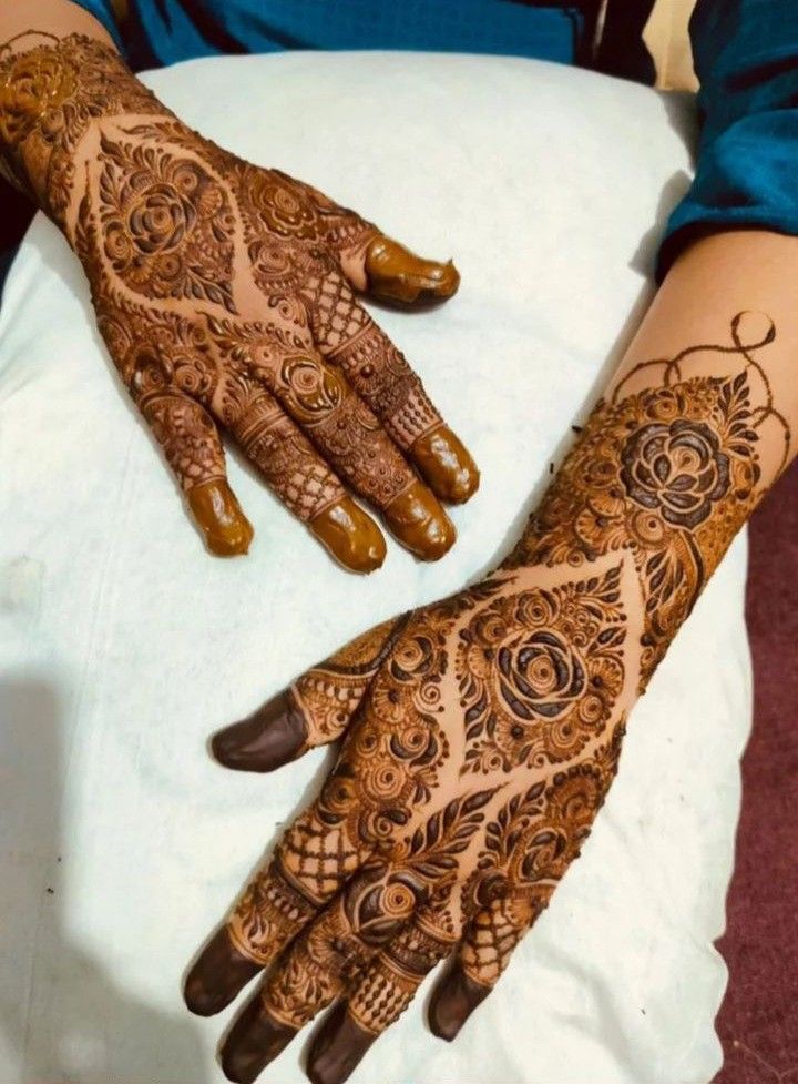 two hands with henna designs on them