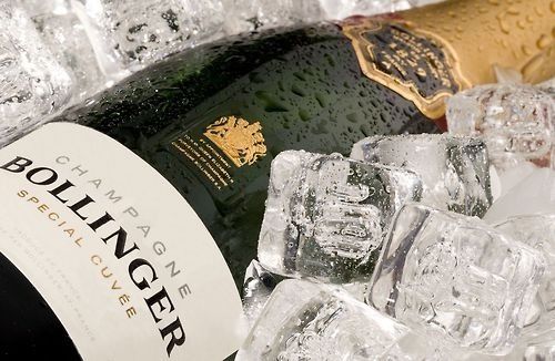 a bottle of champagne sitting next to ice cubes