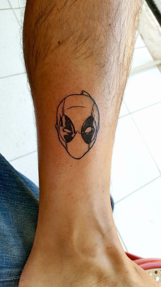 a person with a tattoo on their foot that has an alien face drawn on it