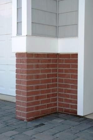 the corner of a brick building with a white door