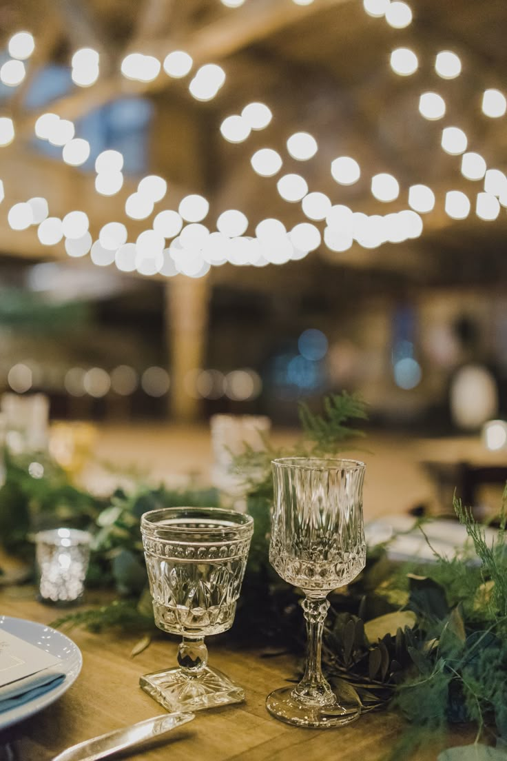 the table is set with silverware and greenery