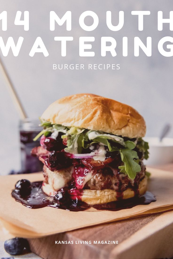 a burger with blueberry sauce and lettuce is on a wooden cutting board