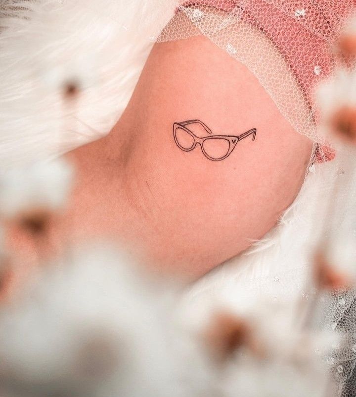 a small tattoo on the back of a woman's shoulder