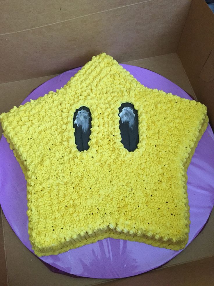 a cake in the shape of a star with eyes and nose on top of a purple plate