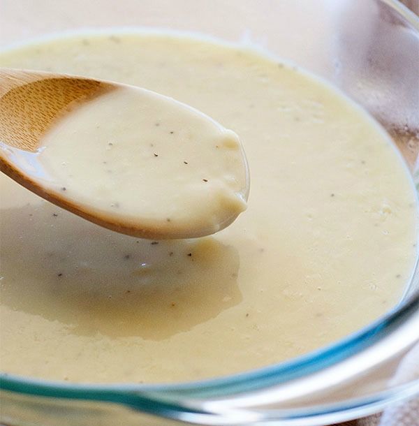 a wooden spoon in a glass bowl filled with liquid