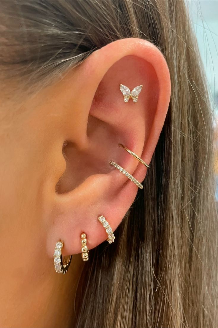 a woman's ear with three different types of piercings