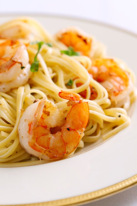 a white plate topped with pasta and shrimp