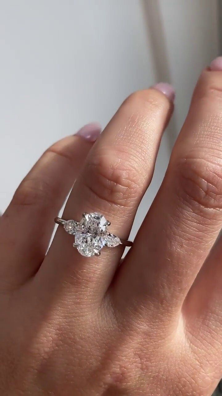 a woman's hand with a diamond ring on it