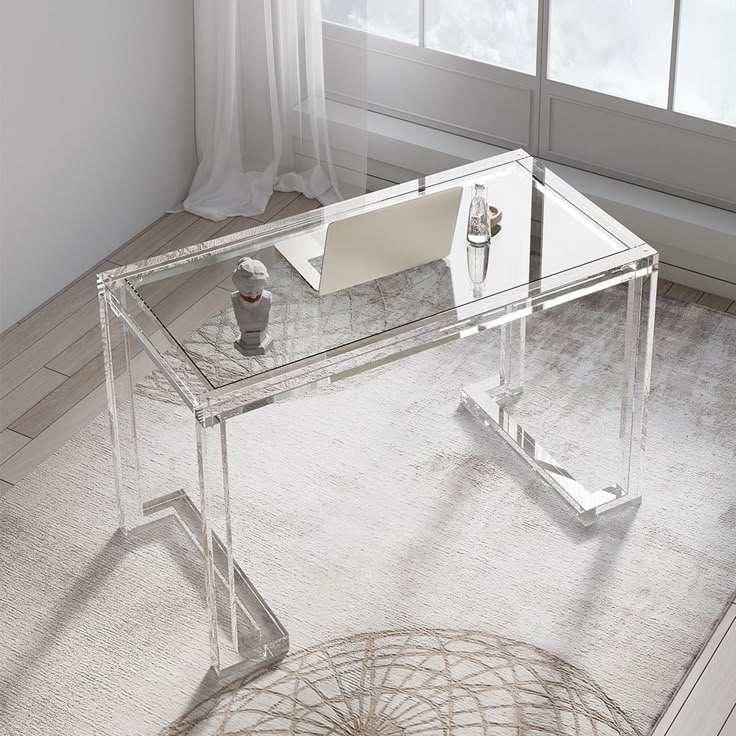 a clear glass desk with a computer on it in front of a white rug and window