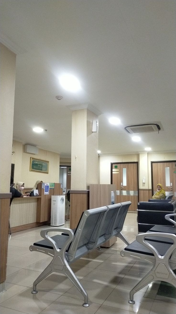 two lounge chairs sitting in the middle of a room with white tile on the floor