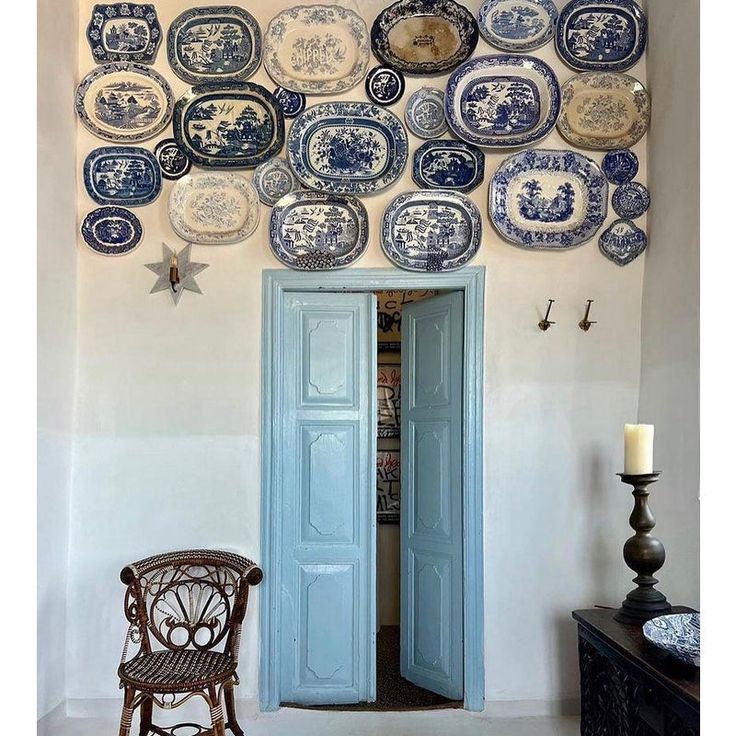 a room with plates hanging on the wall and a chair in front of an open door