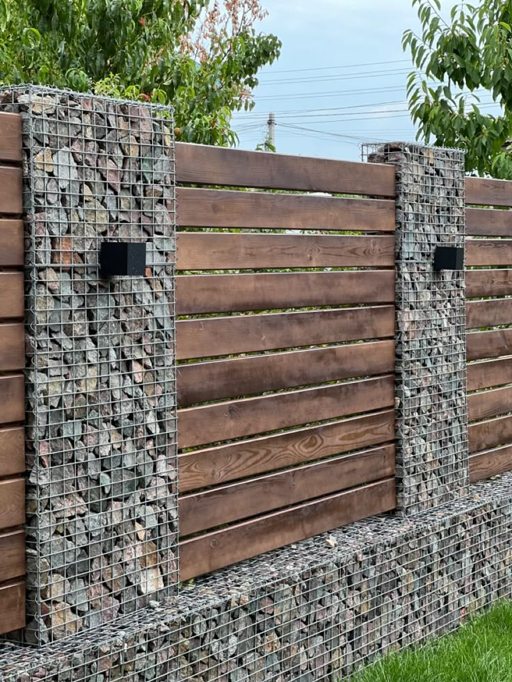 a wooden fence made out of rocks and stones