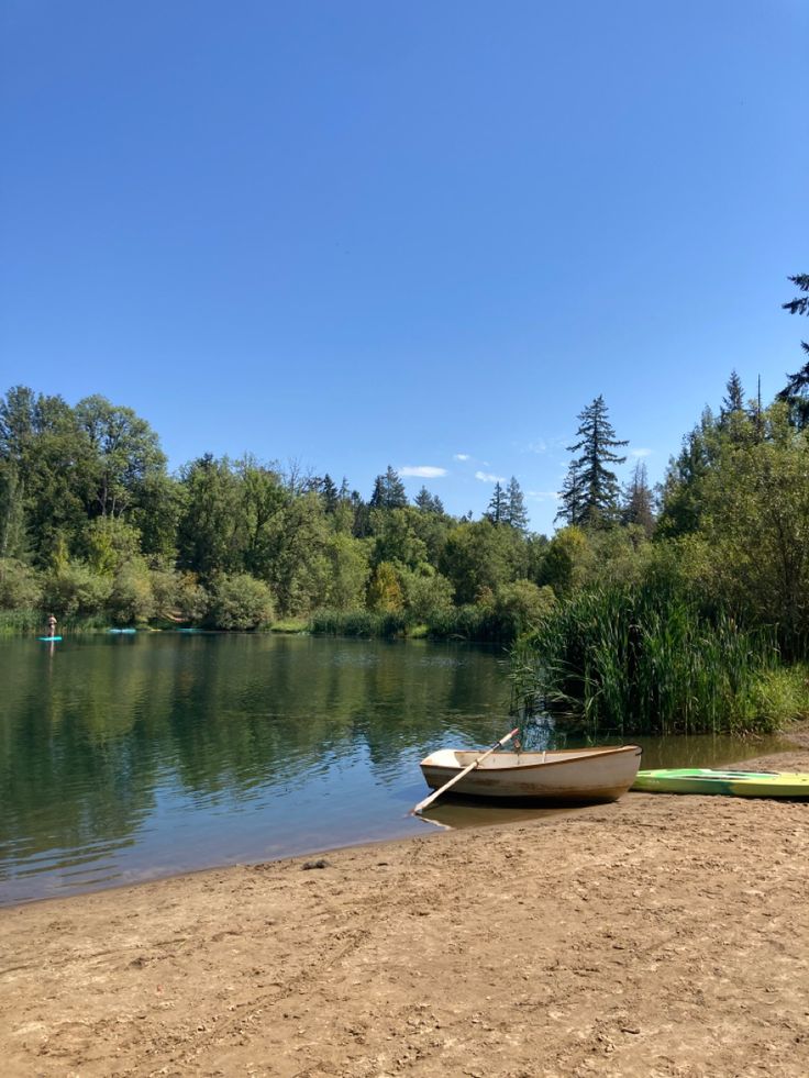 two canoes sitting on the shore of a lake