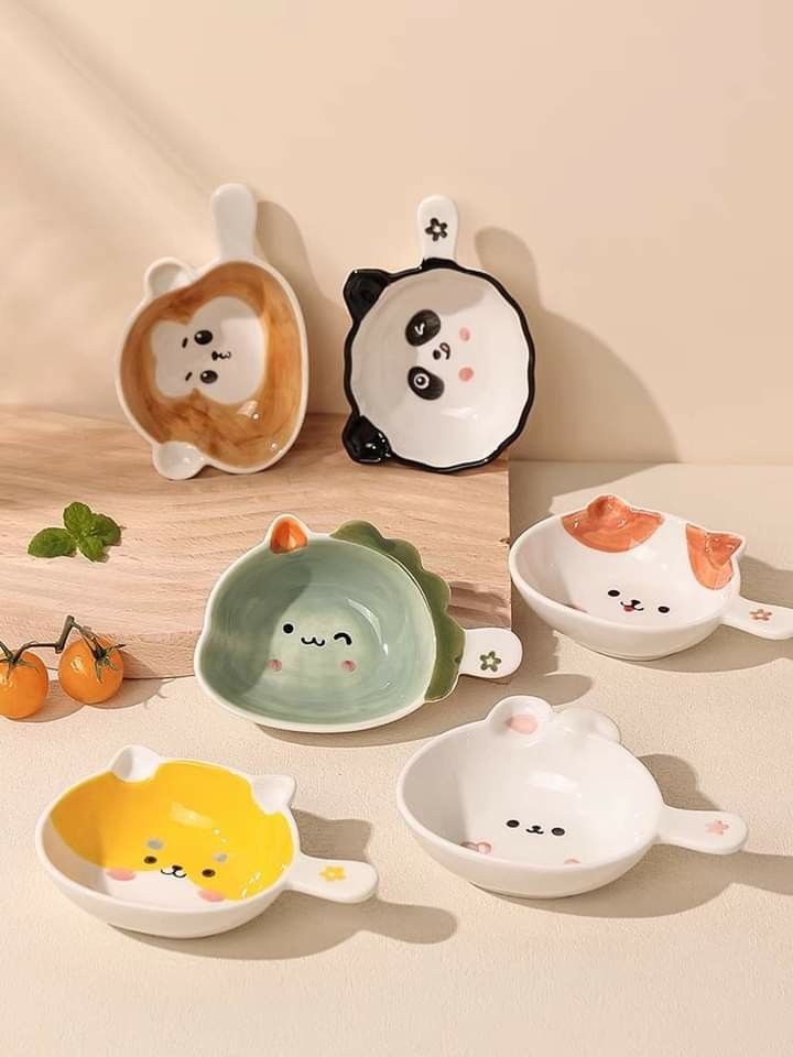 small ceramic bowls with different designs and animals on the sides, sitting on a table