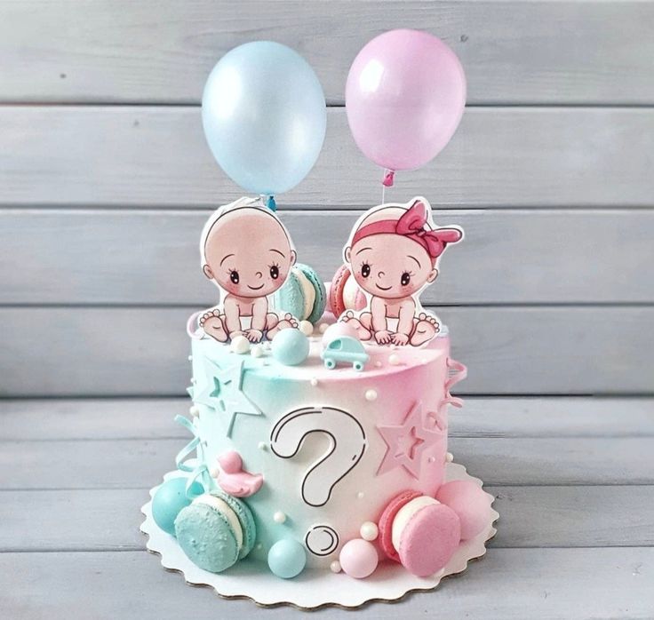 two babies on top of a cake with balloons in the shape of a question mark