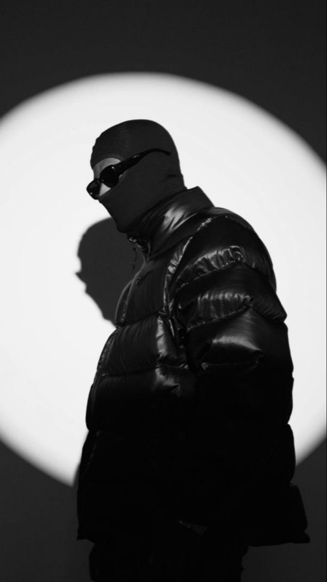 black and white photograph of a man in front of a large moon with his shadow on the wall