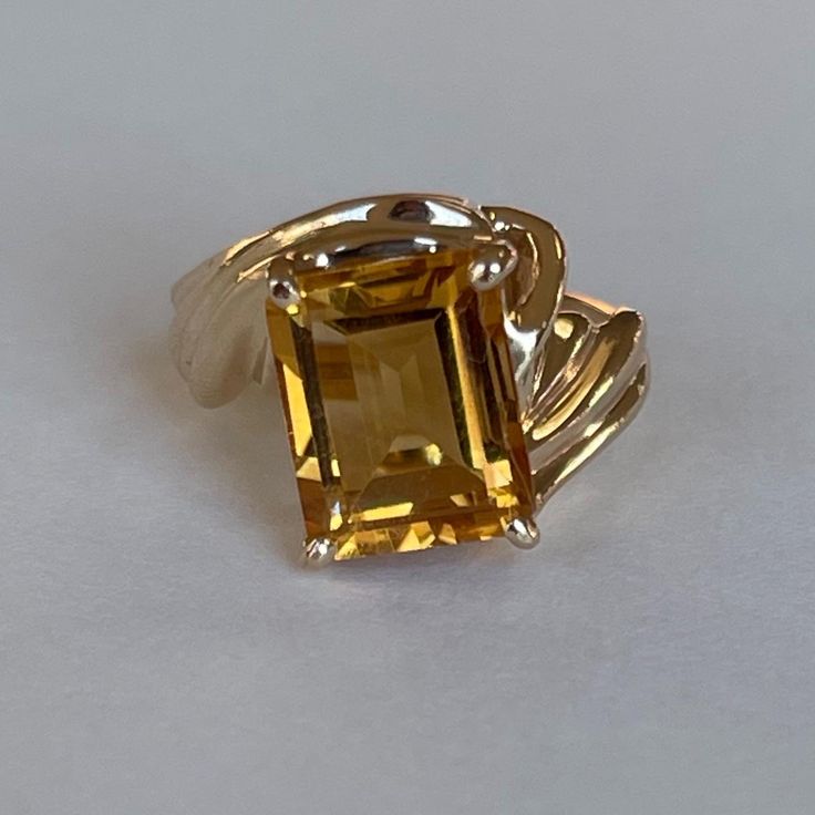 Vintage 14K Citrine Ring with Ribbed Bypass Band, Size 3.5, 4.2grams, November Birthstone  Weight: 4.2 grams Stones: Citrine Size Stone: ca. 10mm x 7.5mm Color Gemstone: Honey-Orange  Number of Gemstones: 1 Cut: Emerald Material: 14 Karat Yellow Gold Band Width: ca. 2mm at smallest point Marking: symbol, 14KP  Condition: Very good preowned with light usage throughout -refer to pictures for condition.  All jewelry will be professionally cleaned before shipping and come in a beautiful little gift box. Returns accepted but are subjected to a 8% restock fee. Returns are only accepted for national orders. Classic Hallmarked Citrine Jewelry, 14k Gold Gemstones With Polished Finish For Anniversary, Classic Gold Gemstones With Polished Finish, Emerald Cut Hallmarked Topaz Ring In 14k Gold, Classic Hallmarked Gold Gemstones, Hallmarked Emerald Cut Yellow Gold Topaz Ring, Hallmarked Citrine Ring With Emerald Cut, Sterling Silver Yellow Gold Topaz Ring With Polished Finish, Yellow Gold Topaz Ring In Sterling Silver