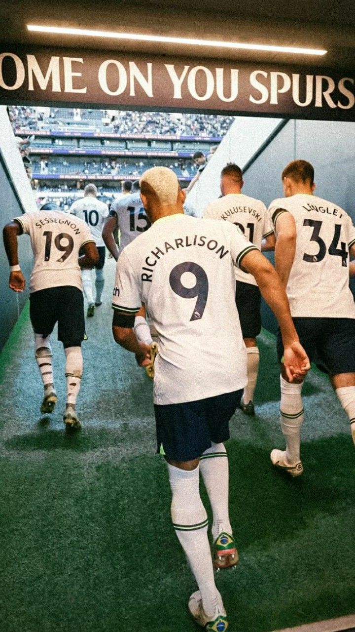 there are many soccer players walking down the tunnel