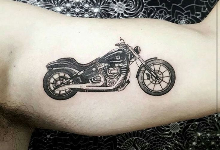 a black and white photo of a motorcycle tattoo on the right arm, with an intricate design