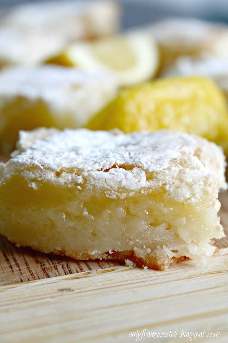 lemon bars are sitting on a cutting board