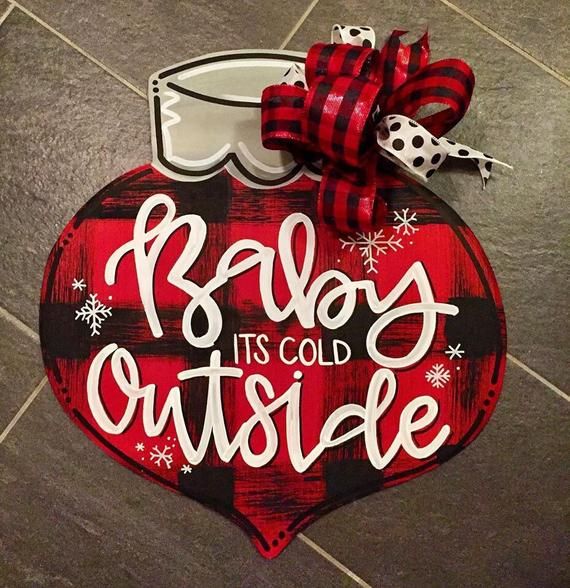 a red and black plaid heart shaped ornament with the words baby it's cold outside