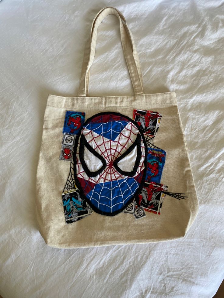 a spider - man tote bag on a bed