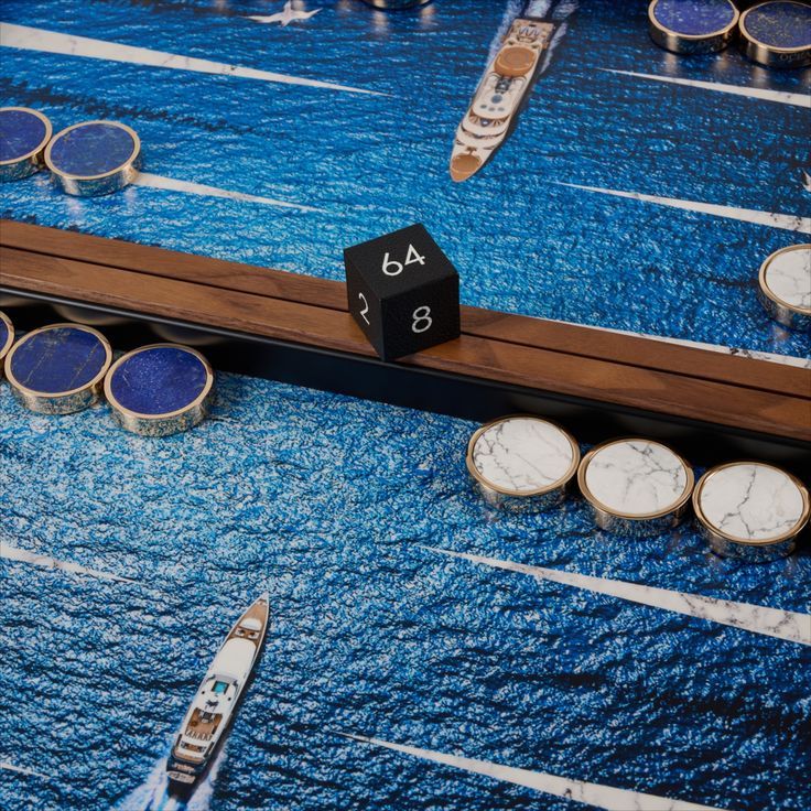 a close up of a board game with dices and boats in the water behind it