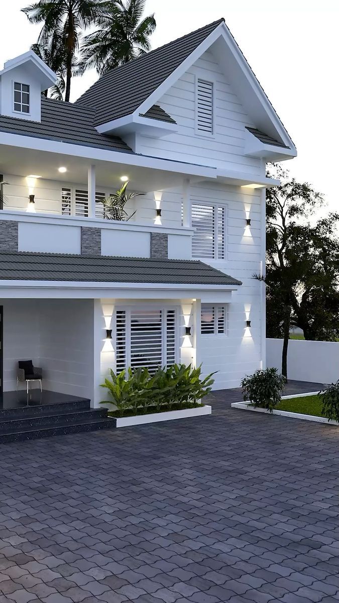 a large white house with lights on it's windows and balconies in the front